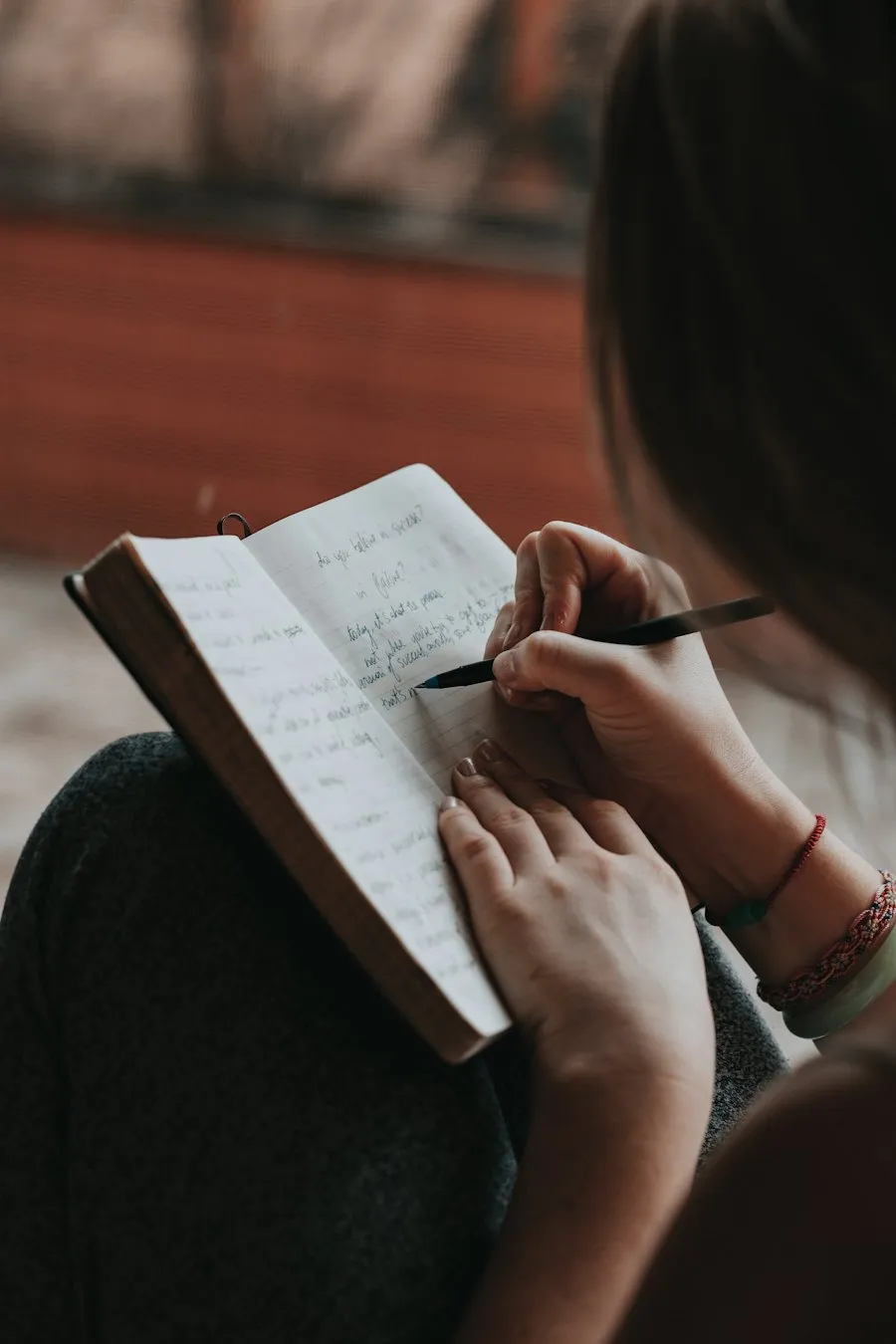 Una escritora con su cuaderno abierto, escribiendo a mano